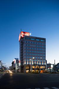 ein großes Gebäude mit einem Coca-Cola-Schild darauf in der Unterkunft Kochi Hotel in Kōchi