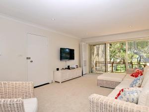a living room with a couch and a tv at Bay Parklands 32 fantastic unit with air conditioning pool tennis court and spa in Shoal Bay