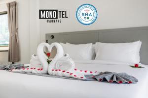 Dois cisnes feitos para parecer pássaros sentados numa cama. em Monotel Aonang em Praia de Aonang