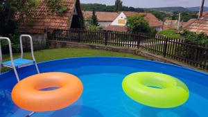 two orange and green inflatable balls in a swimming pool at Pincedombi in Cserépfalu