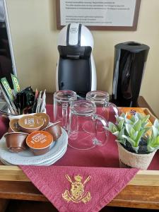 a table topped with glasses and a coffee maker at Rowing Hotel in Trakai