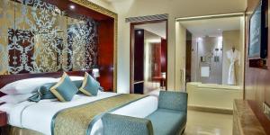 a hotel room with a bed and a chair at Crowne Plaza Ahmedabad City Centre, an IHG Hotel in Ahmedabad