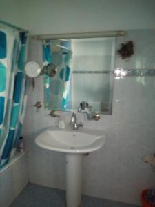 ギシオにあるΕξοχικό σπίτι ΚΑΝΤΗΡΑΚΑΣのバスルーム(白い洗面台、鏡付)