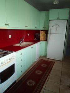 a kitchen with white cabinets and a white refrigerator at Εξοχικό σπίτι ΚΑΝΤΗΡΑΚΑΣ in Gythio