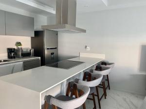 a kitchen with a counter with a row of chairs at Nautico departamento Marina Vallarta in Puerto Vallarta