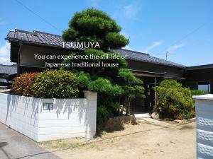 a building with a sign on the side of it at TSUMUYA in Naoshima