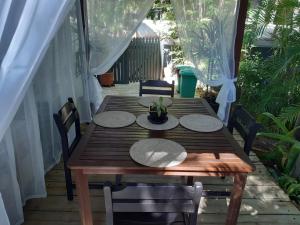 a wooden table on a porch with chairs and a table at Casuarina in Yeppoon