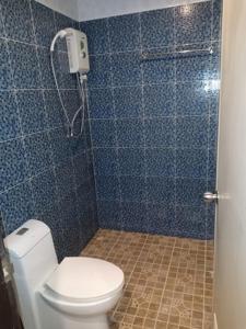 y baño de azulejos azules con aseo y ducha. en Southern Star Resort, en Norte de Pattaya