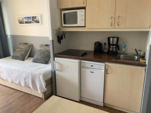 a small kitchen with a bed and a microwave at Appartement Grimaud bord de mer in Grimaud