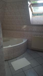 łazienka z wanną i oknem w obiekcie Bliss apartment w mieście Tata