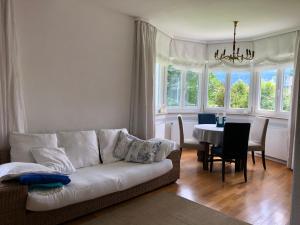 Ferienhaus Chiemsee في أوبيرسي: غرفة معيشة مع أريكة بيضاء وطاولة