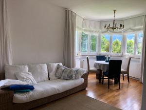 ein Wohnzimmer mit einer weißen Couch und einem Tisch in der Unterkunft Ferienhaus Chiemsee in Übersee