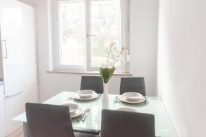 une table à manger avec des chaises et un vase de fleurs dans l'établissement Studio ENIG, à Izola