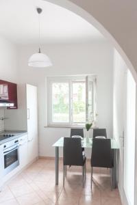 une salle à manger avec une table et des chaises ainsi qu'une cuisine dans l'établissement Studio ENIG, à Izola