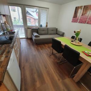 cocina y sala de estar con mesa y sofá en Apartments Mojstrana - Kekec, en Mojstrana