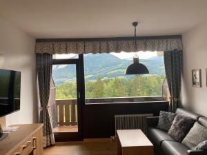 a living room with a couch and a large window at Apartment Sandra in Bad Goisern