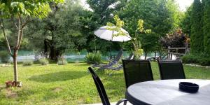 a table and chairs with a table and an umbrella at simply-una in Bihać