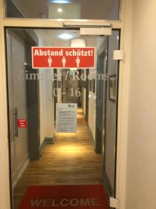 a hallway in a building with a sign on the door at Hotel Wagner im Dammtorpalais in Hamburg