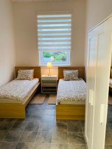 a bedroom with two twin beds and a window at Virginija Guest House in Palanga