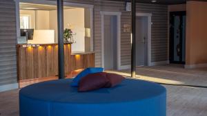 a blue ottoman with a pillow on top of it at Hotell Klövsjöfjäll in Klövsjö +41 photos