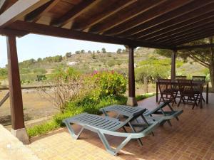 eine Terrasse mit 2 Gartenstühlen und einem Tisch in der Unterkunft Casa Rural El Pajar in El Pinar del Hierro