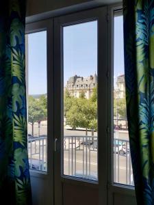 ventana con vistas a la calle y a los edificios en Grand appartement sur les bvd à 2 pas de la gare, en Valence