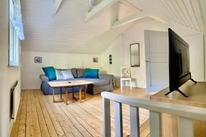a living room with a couch and a tv at Nommen Fishing Cottages in Vetlanda