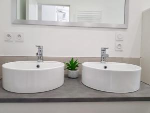2 lavabos blancos en un baño con espejo en Grand appartement sur les bvd à 2 pas de la gare, en Valence