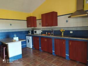 a kitchen with red and blue cabinets and a dishwasher at Casa Rural El Pajar in El Pinar del Hierro
