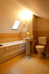 uma casa de banho com uma banheira, um lavatório e um WC. em Casa iRMA - Rooms for rent em Bacau