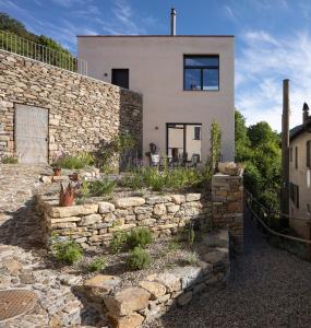 une maison en pierre avec un mur de retenue en pierre dans l'établissement House of retreat Strada Vegia de Brén 9, à Breno