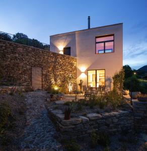 a house with a stone wall and a patio at House of retreat Strada Vegia de Brén 9 in Breno