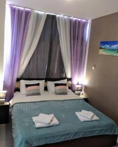 a bedroom with a large bed with purple curtains at Blue Marine Ap 26 in Ravda
