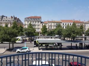 un aparcamiento con una parada de autobús y un autobús en Grand appartement sur les bvd à 2 pas de la gare, en Valence