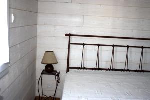 1 dormitorio con 1 cama y 1 lámpara en una mesa en Au Macareux, en Gruissan