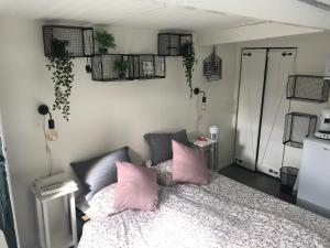 1 dormitorio con 1 cama con almohadas rosas en Het Zonnetje, en Zandvoort