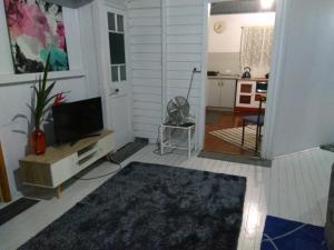 a living room with a television and a kitchen at Spacious Suite in Townsville