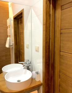 La salle de bains est pourvue d'un lavabo blanc et d'un miroir. dans l'établissement Centrally located apartment overlooking Vermanes Park, à Riga
