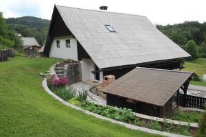 a house with a slate roof and a garden at Sundara Prana in Koprivnik v Bohinju