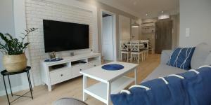 Televízia a/alebo spoločenská miestnosť v ubytovaní Apartament Capri