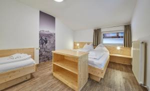 a hotel room with two beds and a window at Ski & Bike Appartements Forsthaus in Saalbach Hinterglemm