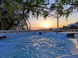 a hot tub with the sunset in the background at Apartments Dalmatia Blue in Mlini