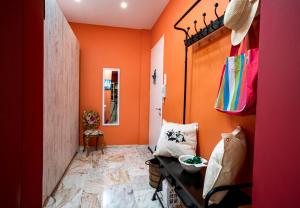 a hallway with orange walls and a table in a room at Casa de Colores en Corfu! in Corfu Town +9 photos