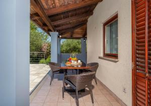 een patio met een tafel en stoelen en een raam bij Casa Vian in Pula