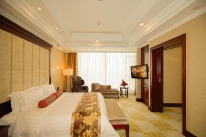 a hotel room with a large bed and a living room at Soluxe Hotel Guangzhou - Registration Service and Free Shuttle Bus to Canton Fair Complex in Guangzhou