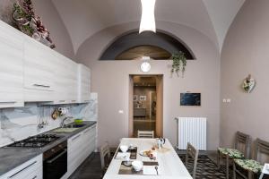 cocina con armarios blancos y mesa en Appartamento Eden Tuscany en Casciana Terme