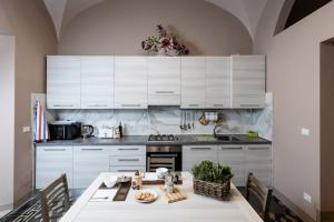 een keuken met witte kasten en een tafel met een bord eten bij Appartamento Eden Tuscany in Casciana Terme