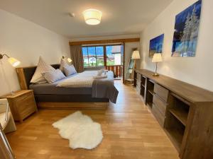ein Schlafzimmer mit einem Bett und einem großen Fenster in der Unterkunft HAUS Alpenoase in Schönau am Königssee
