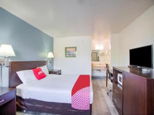 Habitación de hotel con cama y TV de pantalla plana. en OYO Woodland Hotel and Suites en Woodland