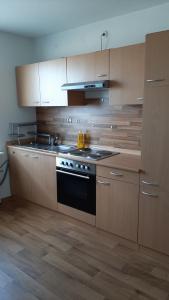 a kitchen with wooden cabinets and a stove top oven at Ferienwohnung bei Schoones in Ganderkesee